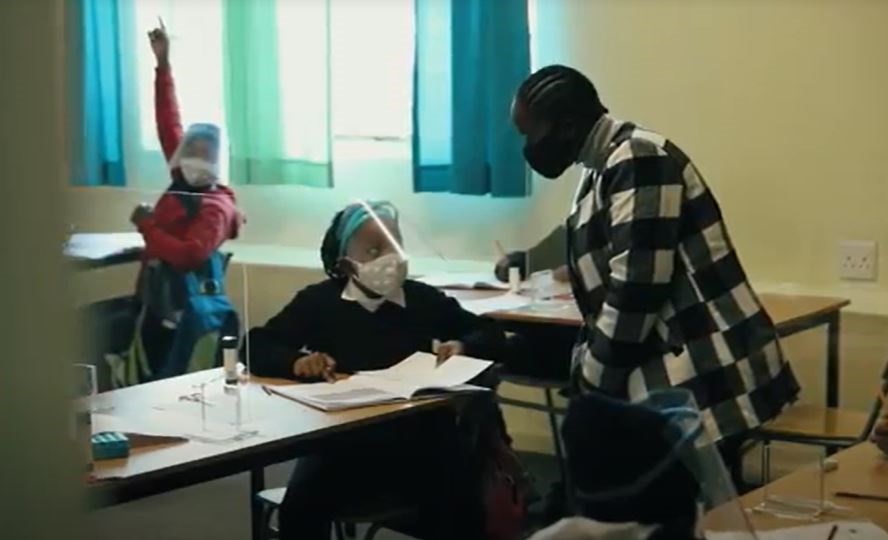 A teacher helps a pupil during class at the Jeppe Park Primary School in Johannesburg. (Screengrab)