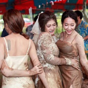 Bride and bridesmaids dance in mud after sudden rainfall at outdoor wedding reception