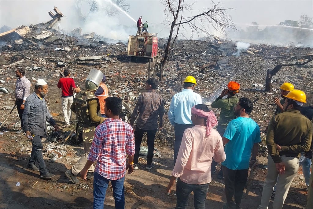 Rescue personnel and local residents gather near a firecracker plant following an explosion at Harda district in India's Madhya Pradesh state on 6 February 2024. 
