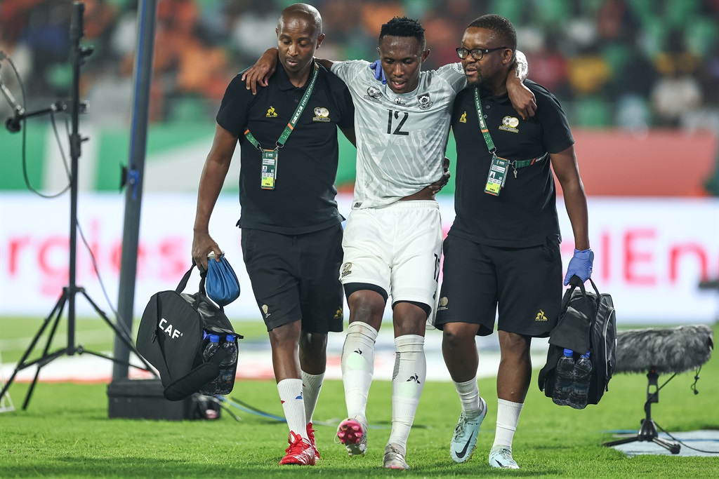 South Africa's defender #12 Thapelo Maseko (C) leaves the pitch after an injury during the Africa Cup of Nations (CAN) 2024 quarter-final football match between Cape Verde and South Africa at the Stade Charles Konan Banny in Yamoussoukro on February 3, 2024. (Photo by FRANCK FIFE / AFP) 