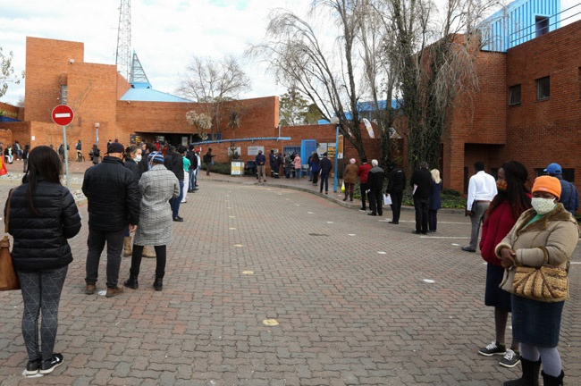 Motorists queue outside a Licensing and Testing Department.
