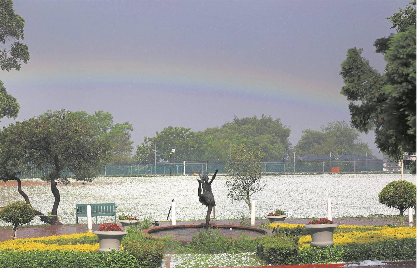 The Wykeham Collegiate’s ice-covered field is surmounted by a rainbow after tennis ball-sized hailstones rained down on Pietermaritzburg on Wednesday. 