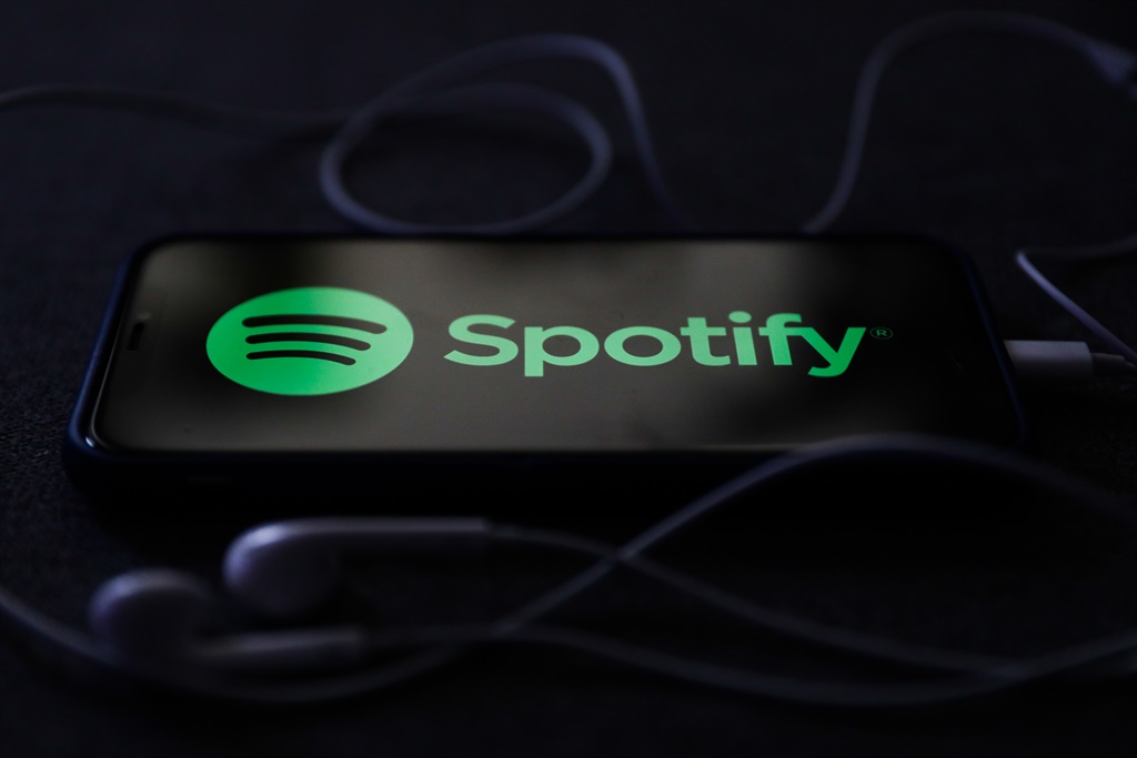 Spotify logo displayed on a phone screen and headphones are seen in this illustration photo taken in Poland on October 18, 2020.