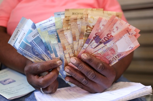 A member of a stokvel counts banknotes before making her contribution during one of their gatherings in Vanderbijlpark, in the south of Johannesburg.