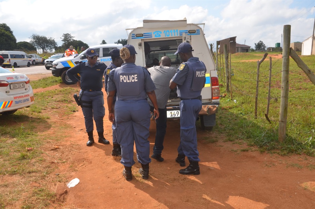 One of the two murder suspects being led into a police van in the Mkhuhlu area, Mpumalanga. Photo by Oris Mnisi