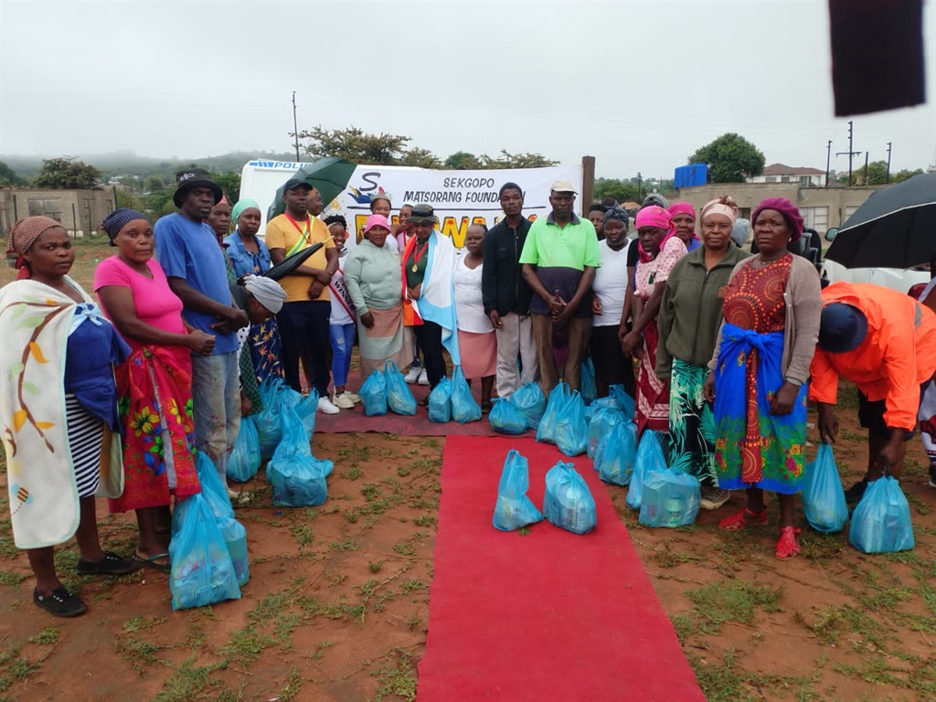 Matsorwane Sekgopo (sixth from left) with some of the needy villagers who received food parcels.