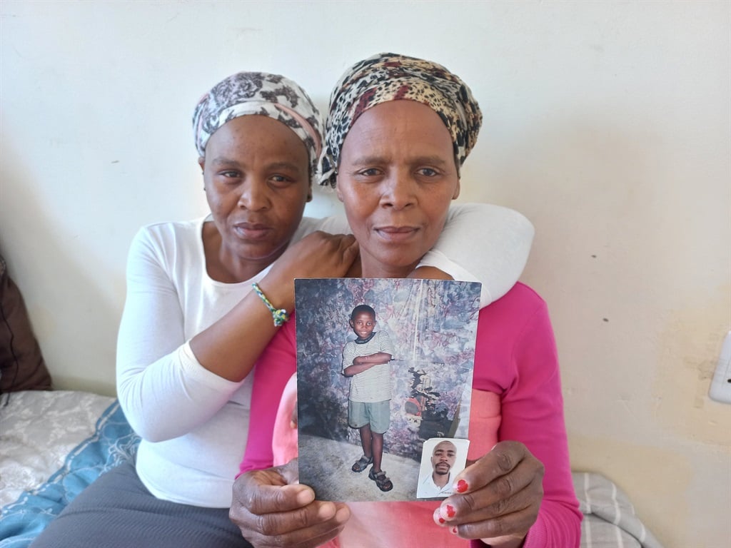 Nokuzola Bente shows pictures of her son. She is supported by her only surviving child, Abongile Bente.