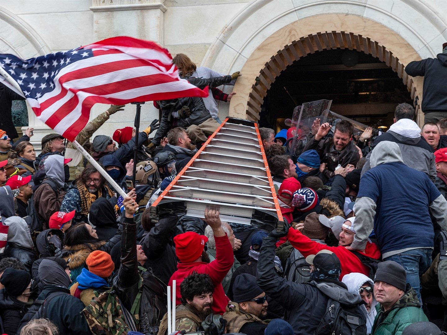 Rioters clash with police using big ladder trying to enter Capitol building through the front doors.  