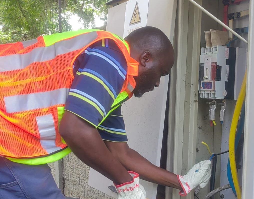 A City Power employee disconnects a service cable from the main circuit breaker to ensure the customer does not illegally reconnect power. 
