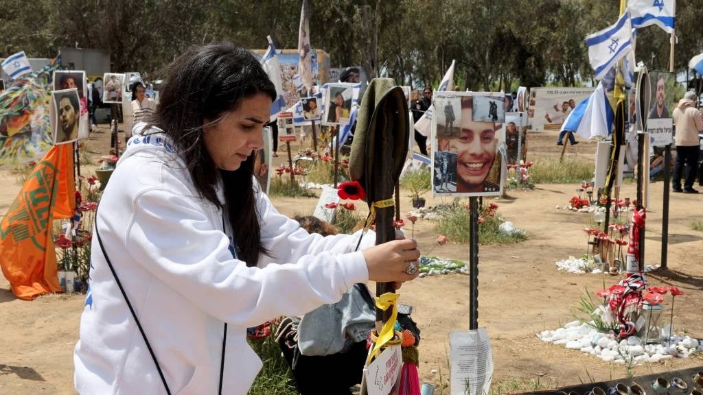 اسرائیلی ها از یک بنای یادبود با پرتره هایی از افرادی که در جریان حمله حماس به جشنواره موسیقی سوپرنوا در 7 اکتبر در محل جشنواره در نزدیکی کیبوتز ریم در جنوب اسرائیل به گروگان گرفته شده یا کشته شدند، بازدید می کنند.  (جک گئز/AFP)