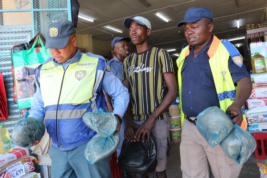 Mnquma Local Municipality law enforcement officials with suspects arrested during the raid.