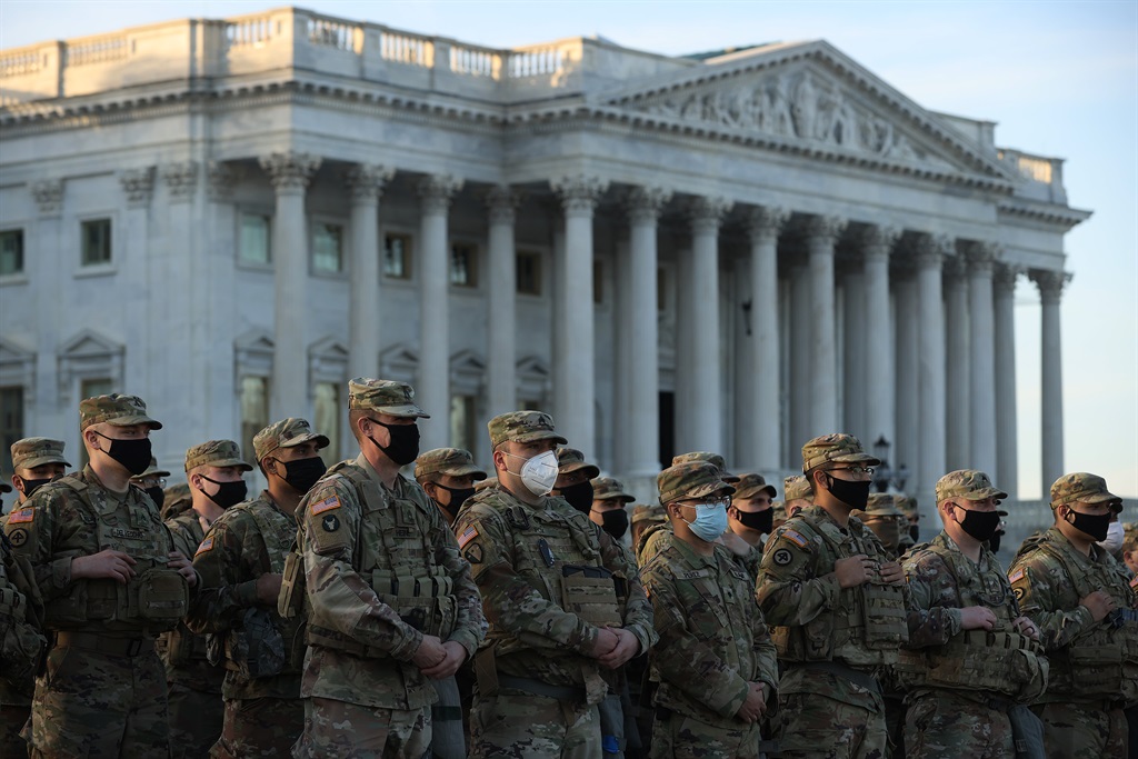 National Guard troops pose for photographers on the East Front of the U.S. Capitol the day after the House of Representatives voted to impeach President Donald Trump for the second time January 14, 2021 in Washington, DC.  (Photo by Chip Somodevilla/Getty Images)