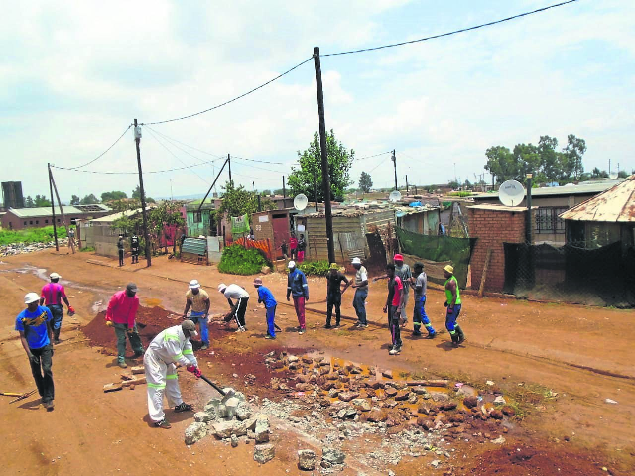 Residents of Silvertown in Bekkersdal fix their road.      Photo by Sammy Moretsi