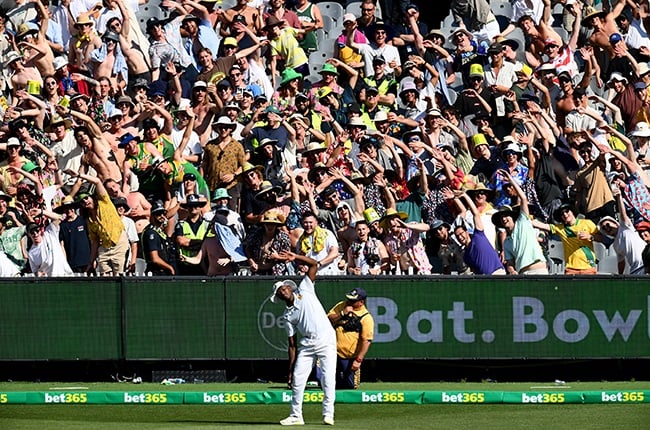 Kagiso Rabada stretches in front of fans at the MCG.