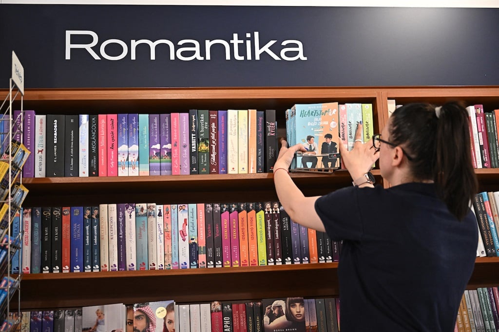 A staff member moves copies of the British graphic novel Heartstopper to the adult books section from the children's books section in a book stores in Budapest in July 2023, after authorities fined retailer Lira Ltd 12 million forints for selling the book to minors and without closed wrapping. (Photo by ATTILA KISBENEDEK / AFP)