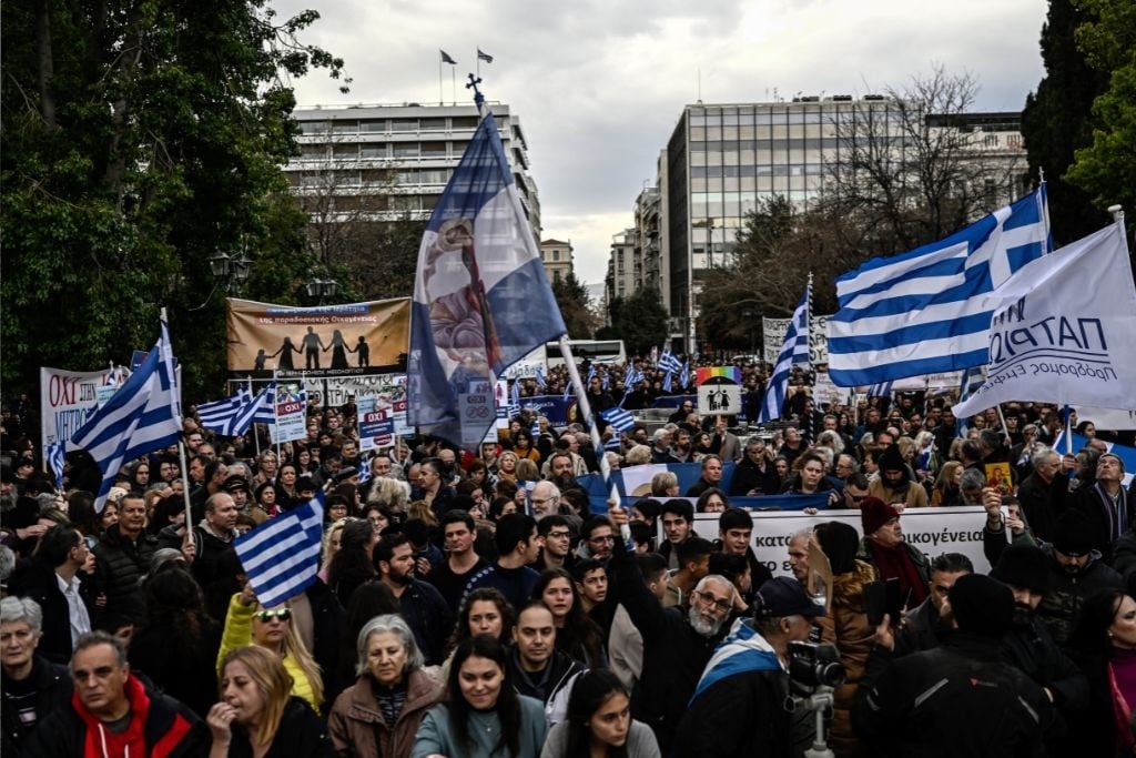 Protesters hold national flags during a demonstration against a reform legalising same-sex marriage and adoption, that will be debated by parliament next week, in Athens on February 11, 2024.  