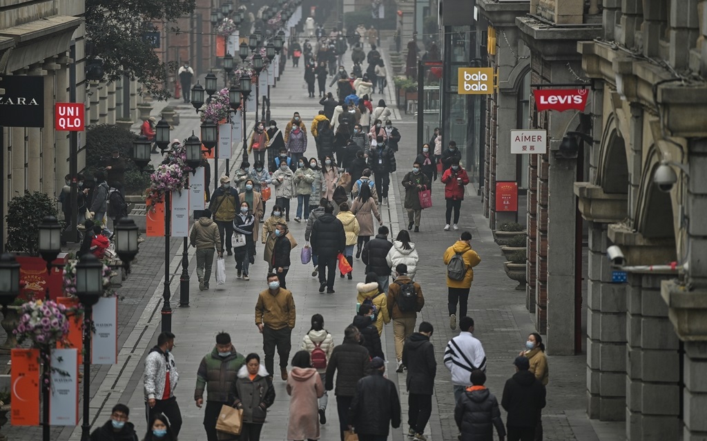 People walk along a pedestrian street in Wuhan, China's central Hubei province, one year after the city went into lockdown to curb the spread of the Covid-19 coronavirus.
