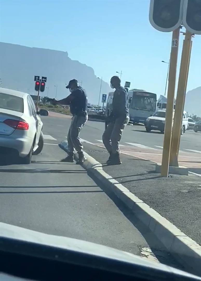 Screengrabs from the viral video of police officers shooting at a motorist’s car tyres.