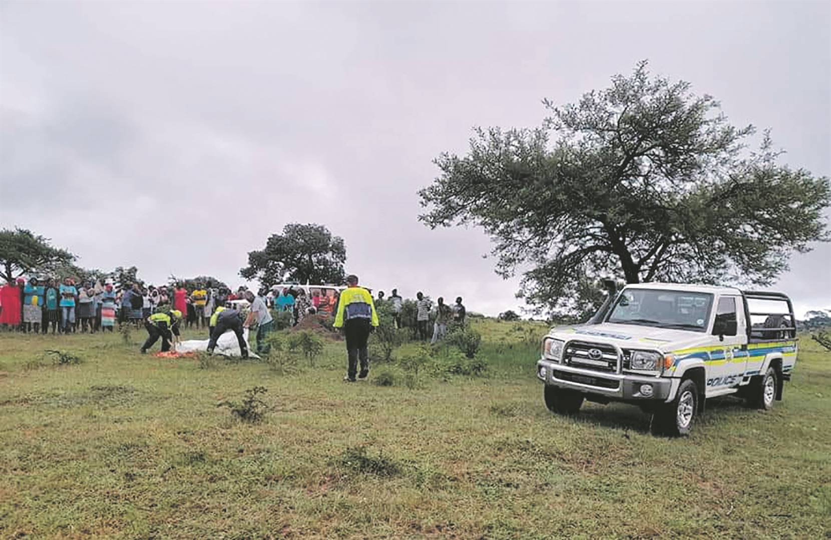 Rescue workers cover the body of a boy who drowned in the Sukani River.