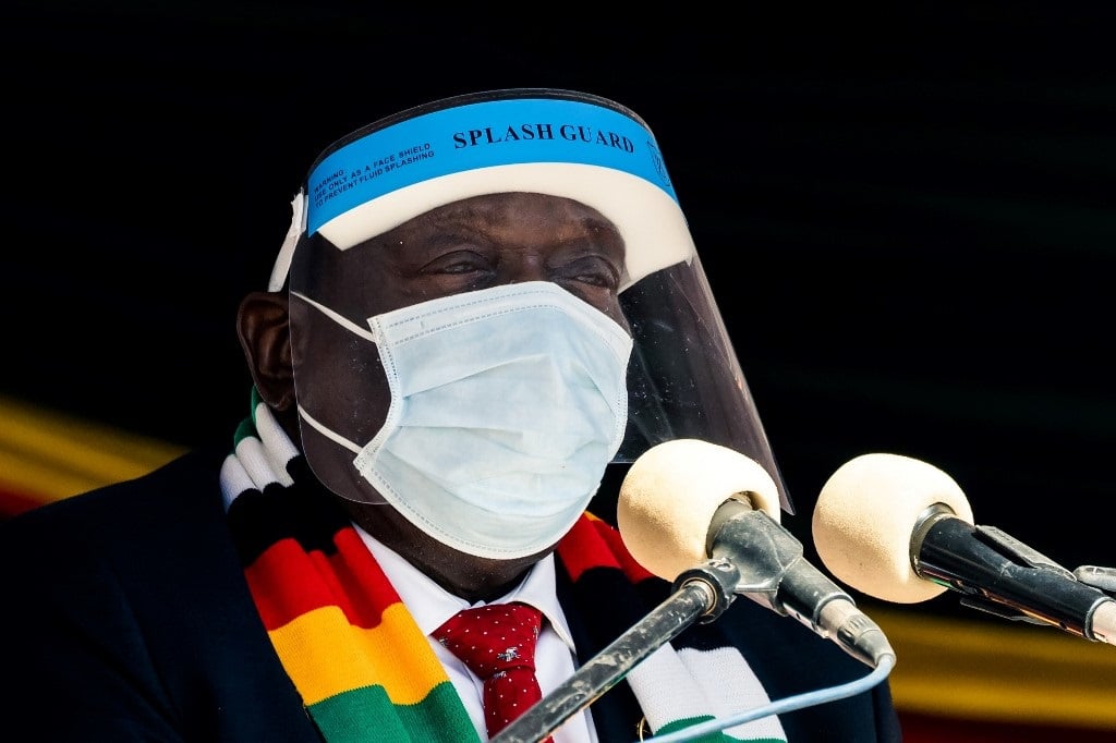 Zimbabwe's President Emmerson Mnangagwa wears a protective face shield and face mask.