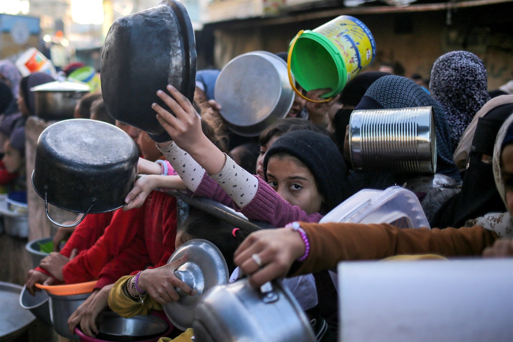 Displaced Palestinians collect food donated by a charity before an iftar meal, in Rafah, on the southern Gaza Strip. (AFP)