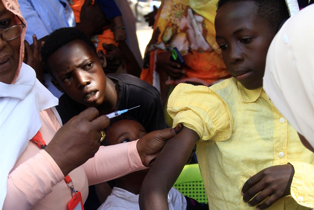 A young Sudanese receives a vaccine shot in Sudan's eastern state of Gedaref on 22 January 2024 during a vaccination campaign against the measles and rubella virus. 