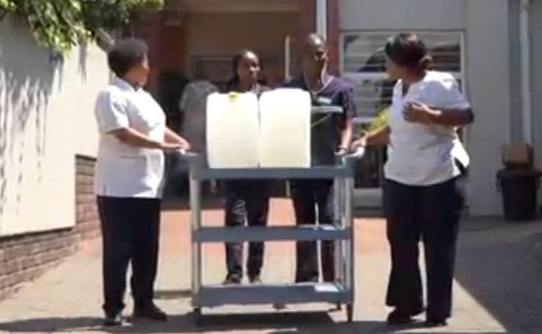 Staff at Zola Community Health Centre Clinic move water amid a shortage. (Thahasello Mphatsoe/News24)