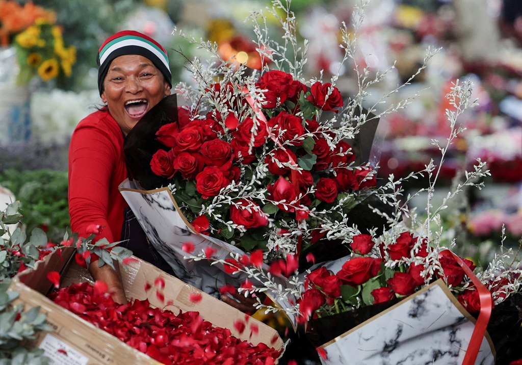 A vendor poses with red roses on Adderley Street Flower Market in Cape Town on Valentine's Day.      