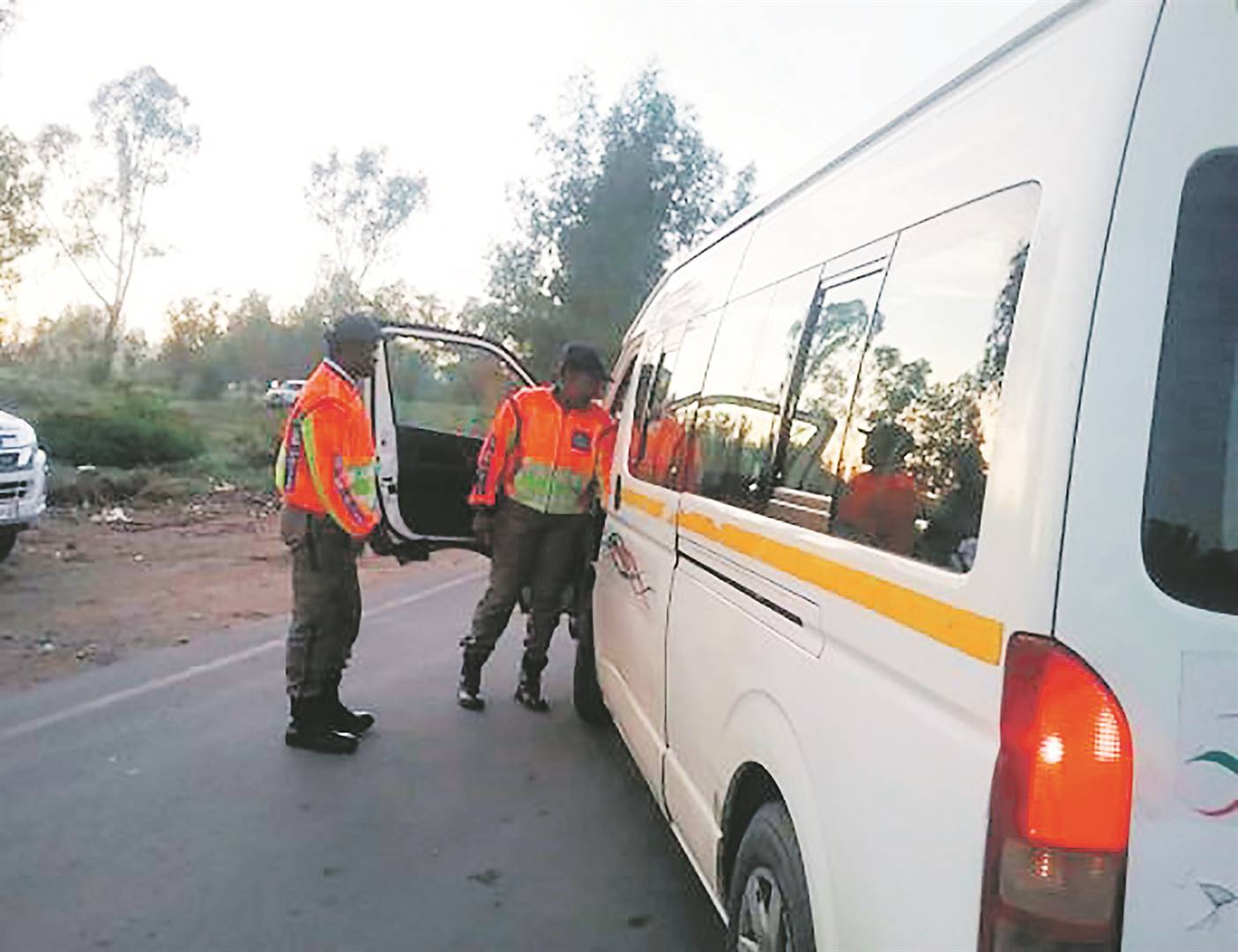 Metro cops stopping and searching a minibus taxi.