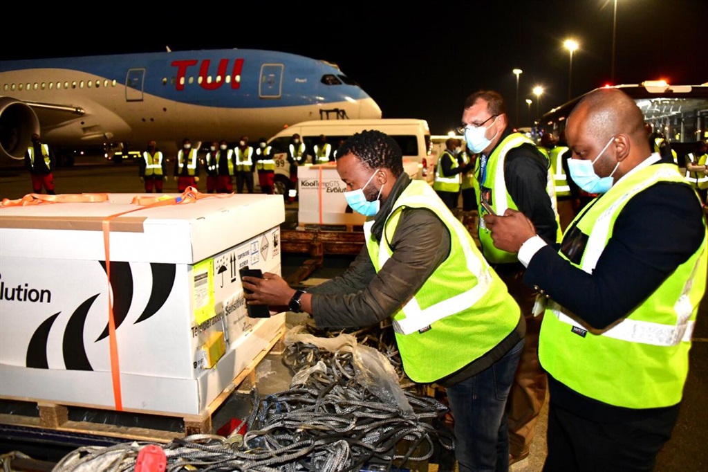 Staff remove a consignment of vaccines from a plane at OR Tambo International Airport.