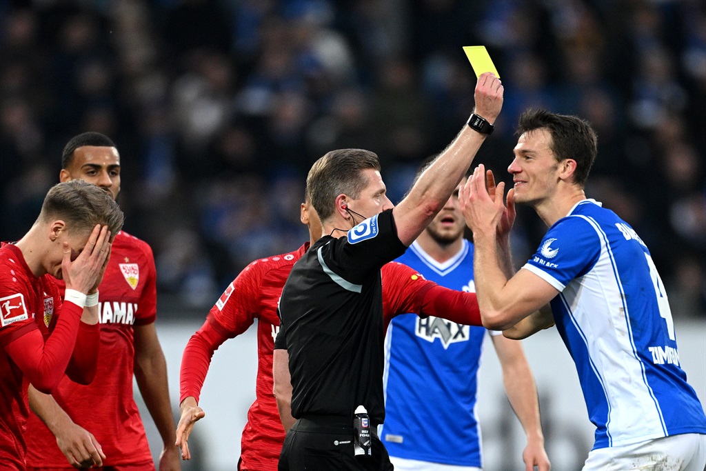 Referee Tobias Welz shows a yellow card to Chris Fuehrich of VfB Stuttgart and Christoph Zimmermann of  Darmstadt 98 during their  Bundesliga match on 17 February. Photo: Matthias Hangst / Getty Images