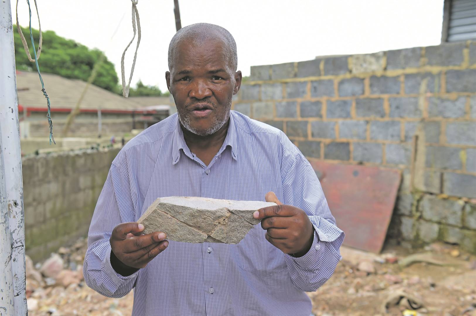 Stephens Khumalo holding a rock he claims is a sign he was close to his loot.        Photos by  Morapedi Mashashe