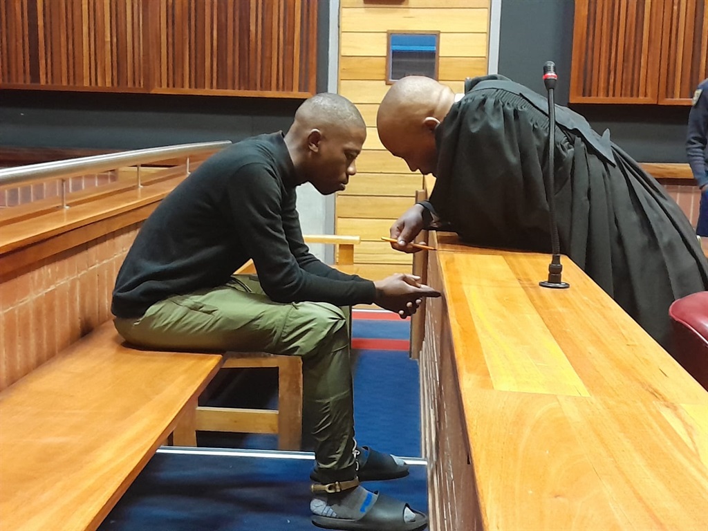 Advocate Vuyo Maqetuka consults with his client Sifiso Mkhwanazi, who is accused of killing sex workers. Photo by Happy Mnguni