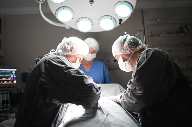 Doctors doing a surgery on operating room in a hospital.