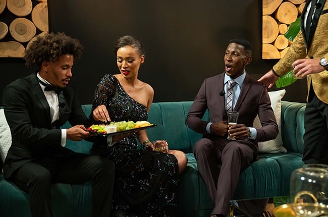 Craig offers Qiniso some grapes while she chats to