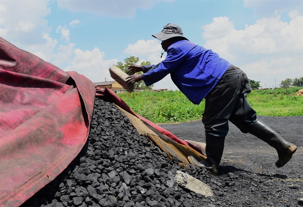 Samuel Ramolefe (58) covering his coal to protect 