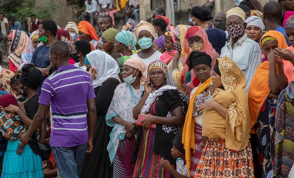 Families wait outside the port of Pemba on 1 April 2021 for the boat of evacuees from the coasts of Palma, Mozambique.