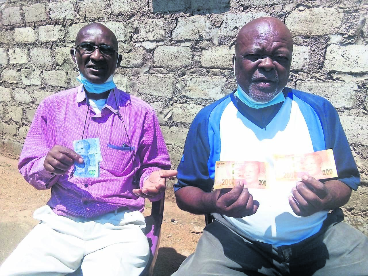 Elias Barries and Jerry Mathabathe of Lephengville with the fake notes after being scammed.   Photo by Raymond Morare