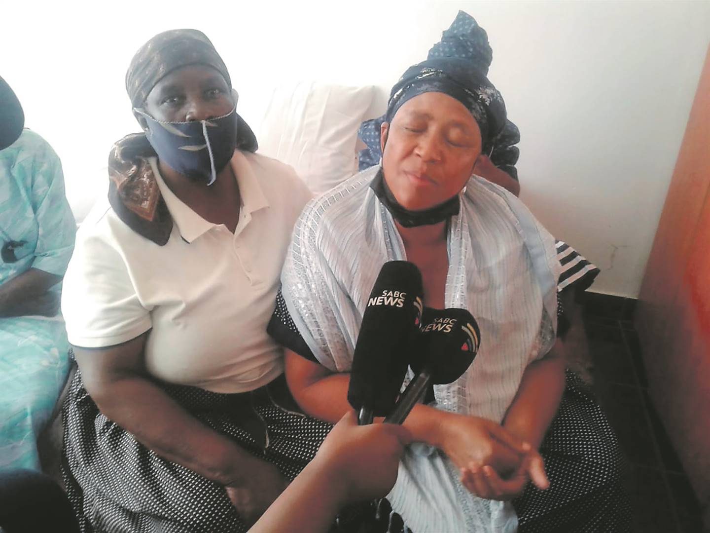 Florah Khune comforted by a family member after a teenager arrested for her daughter's murder was released due to lack of evidence.