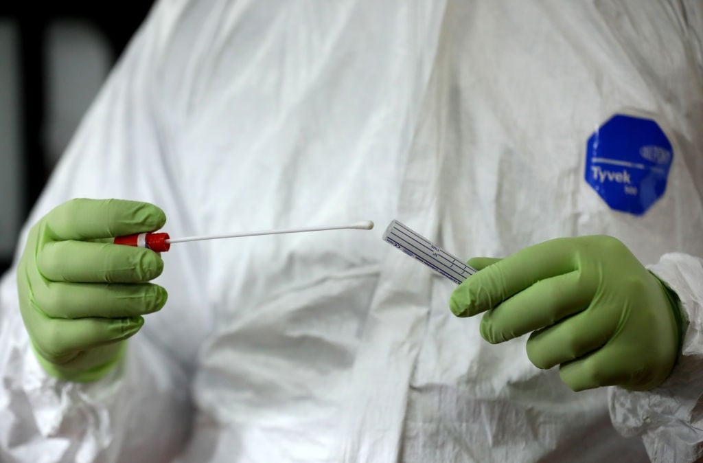 A doctor holds a Covid-19 test swab. 