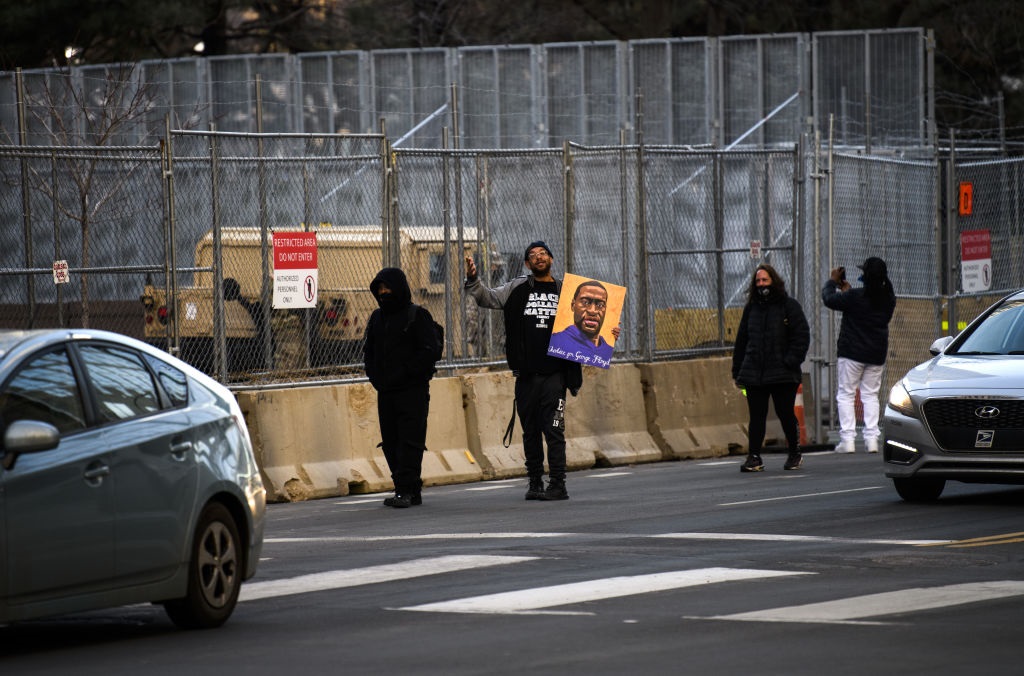 A man carries a portrait of George Floyd outside the Hennepin County Government Center. 