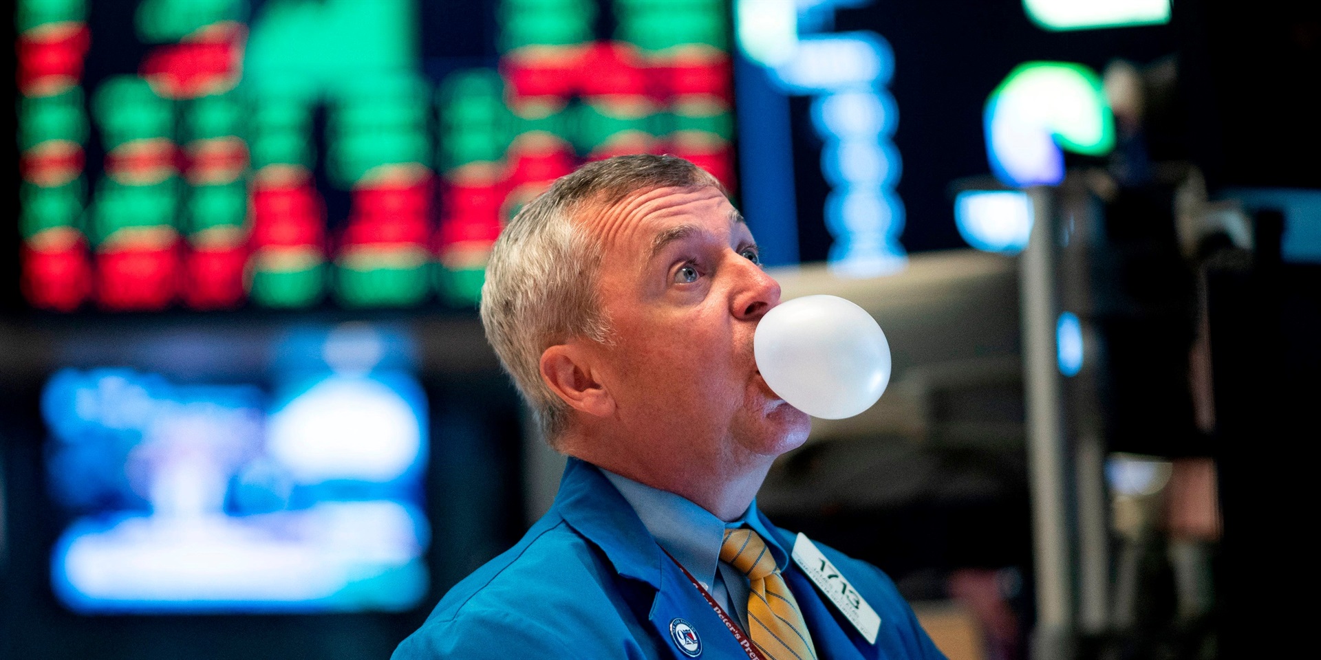 A trader blows bubble gum during the opening bell at the New York Stock Exchange (NYSE) on August 1, 2019, in New York City.
