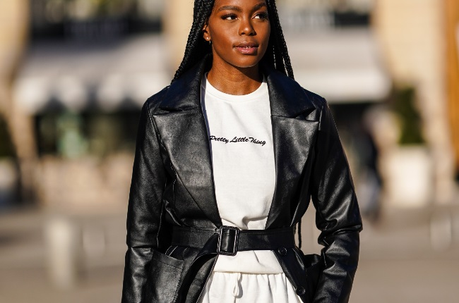 Magalie Kab wears a black leather long coat, a white pullover from Pretty Little Thing, white jogger sportswear pants, in Paris, France. (Photo by Edward Berthelot/Getty Images)