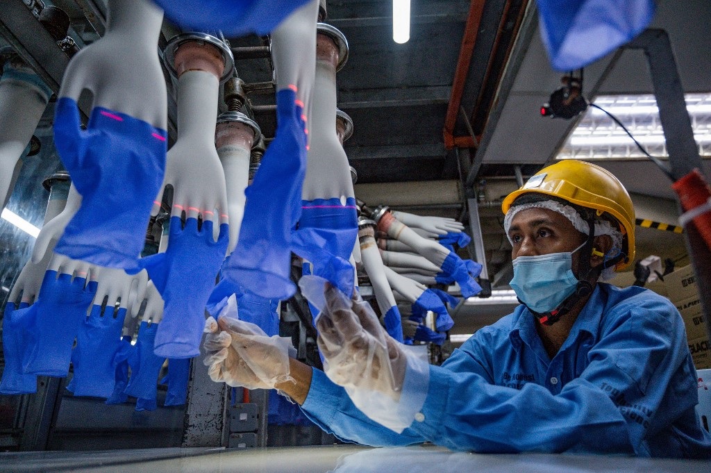 A worker inspects disposable gloves at the Top Glove factory in Shah Alam on the outskirts of Kuala Lumpur. Top Glove, a Malaysian-based company is one of the world's largest rubber glove manufacturer.
