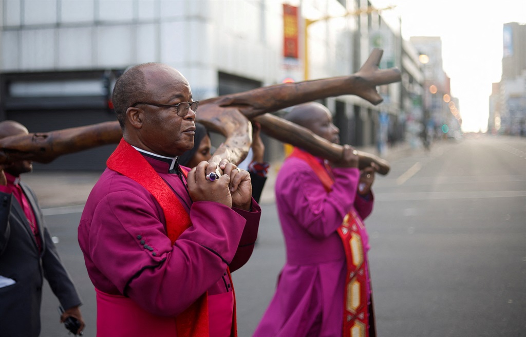 Religious leaders carry a cross during a silent Go