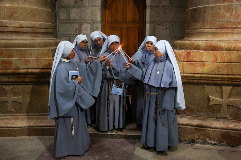 Nuns light candles during the Catholic Washing of 