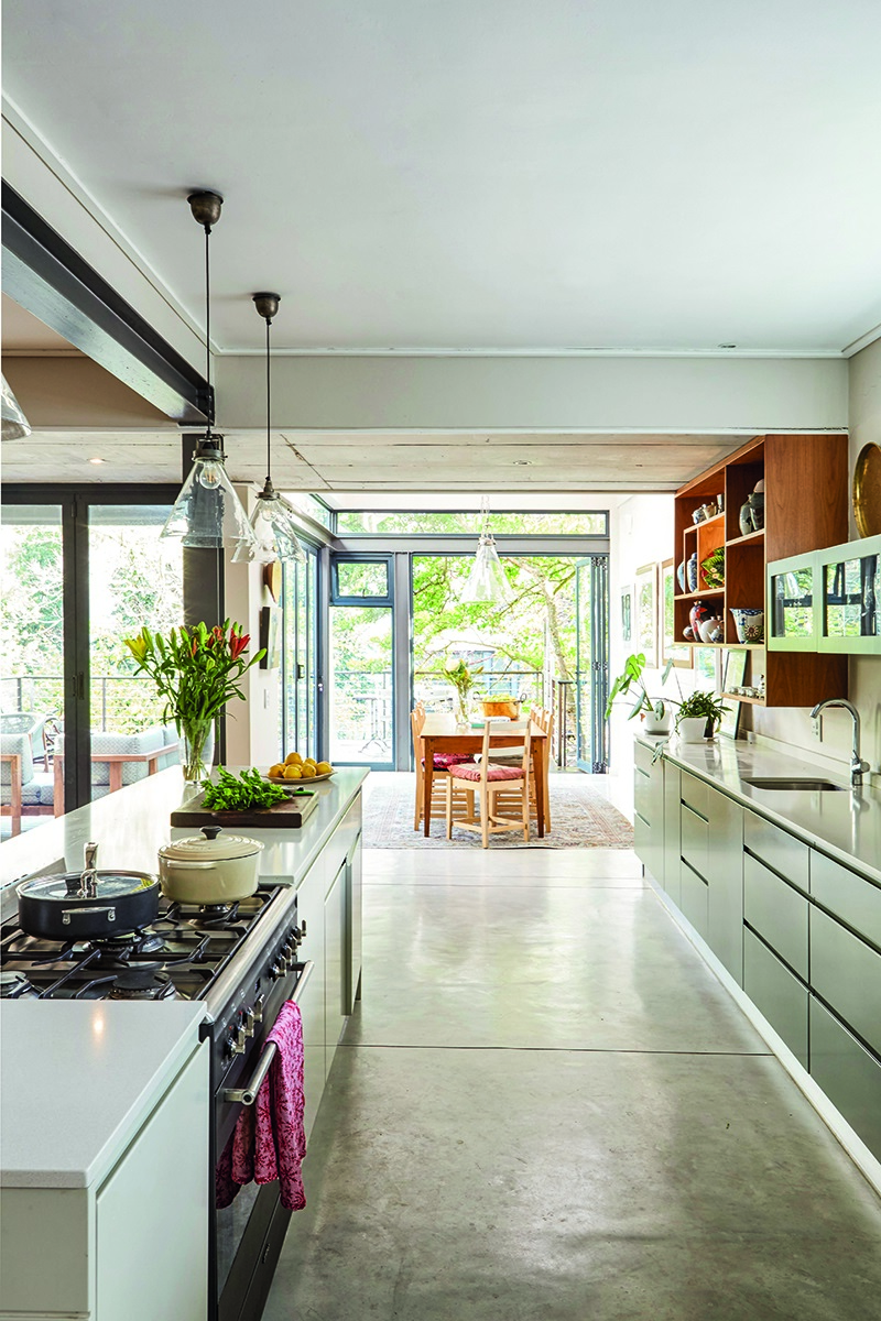 With the redesign of this kitchen, the classic work triangle – with the ideal distance between stove, sink and fridge – was put into effect. And to keep the classic, clean lines as simple as possible, the couple opted for spray-painted handle-free kitchen cabinets.