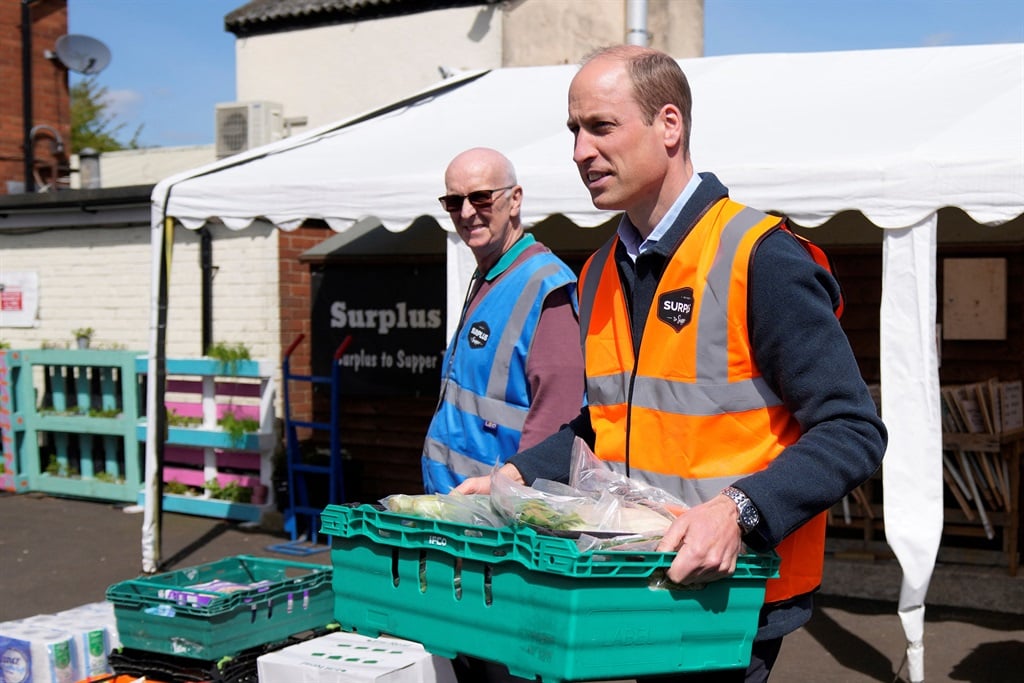 Britain's Prince William, Prince of Wales helps to