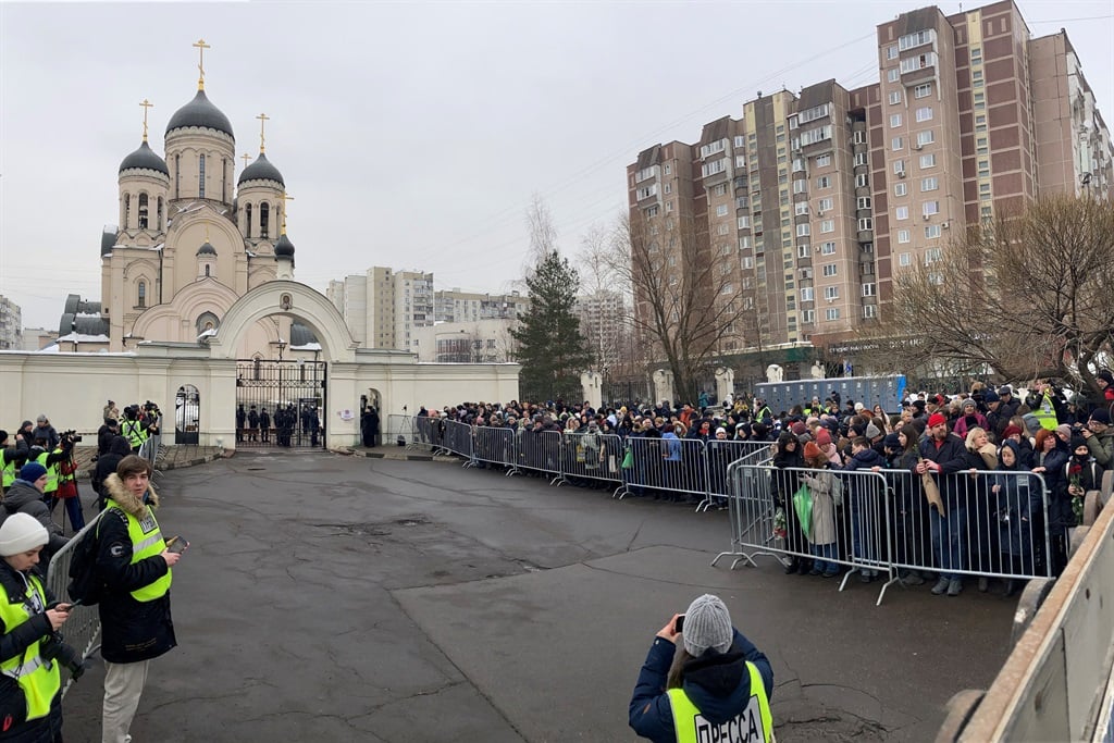 Mourners gather in front of the Mother of God Quen
