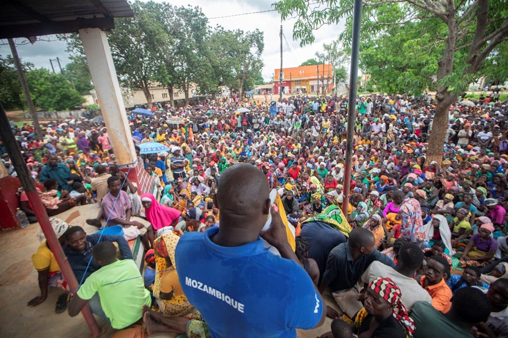 A staff member of the World Food Program (WFP) addresses displaced people who fled jihadism in the province of Cabo Delgado, gathering to received humanitarian aid in the town of Namapa, Erati district of Nampula, Mozambique on 27 February 2024. (Photo by Alfredo ZUNIGA / AFP)